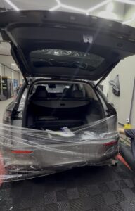 homem instalando o ppf na traseira de um carro