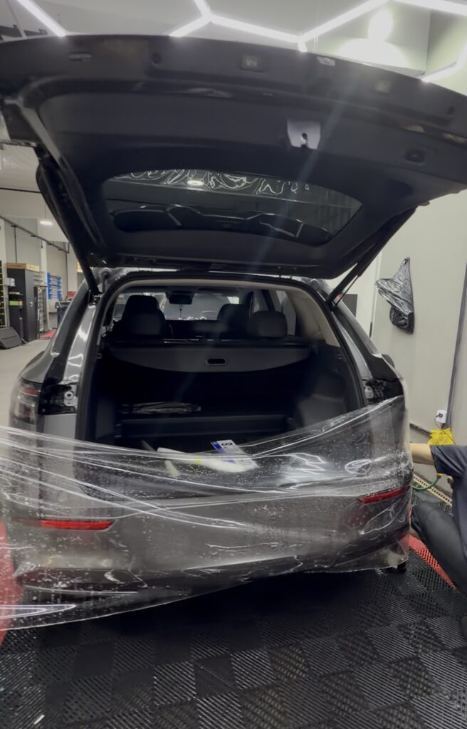homem instalando o ppf na traseira de um carro